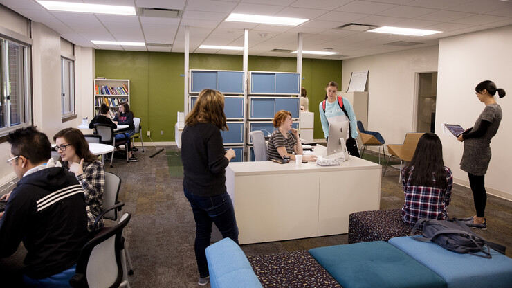 Amanda Love (seated, center) assists Jill Schindler with a question in the Writing Center. Love works the reception desk at the center, greeting students and assisting them as needed.
