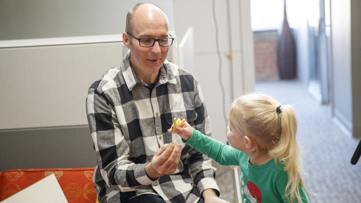 Dave Fitzgibbon shares snacks with a child during a shoot for Nebraska Extension.