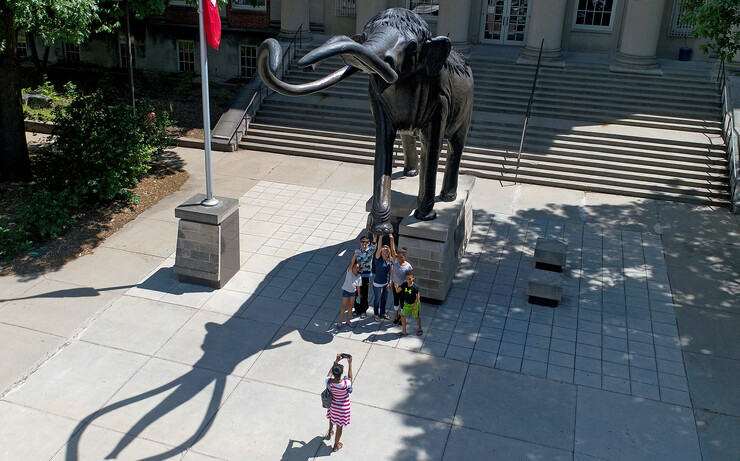 NU State Museum visitors pose for a photo with Archie outside of Morrill Hall.