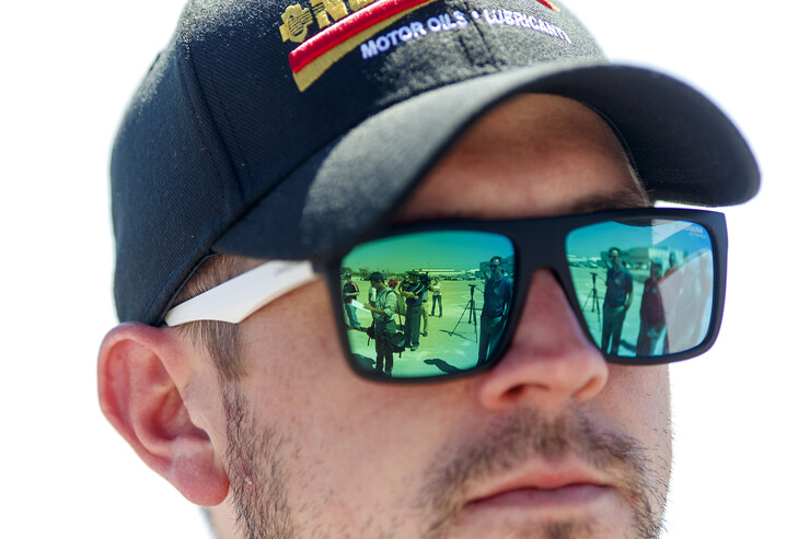 Members of the media are reflected in the sunglasses of NASCAR Xfinity Series driver Michael Annett during the tour.