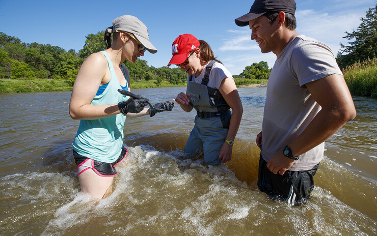Kayla Vondracek (from left), Jessica Corman and Matthew Chen look over a sand sample collected from the Niobrara River. The study was offered through the university's UCARE program and supported Corman's research in the School of Natural Resources.
