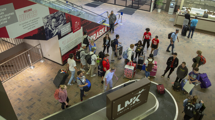 International students gather their luggage as they talk with Nebraska welcome team members in the Lincoln Airport.