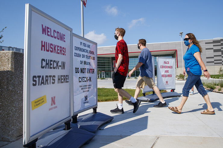 A family walks toward the Devaney Sports Center to check in before beginning the move-in process on Aug. 13.