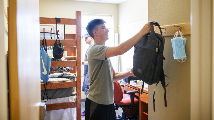 Jack Kinney of Omaha hangs up his backpack in his Knoll Residence Center room.
