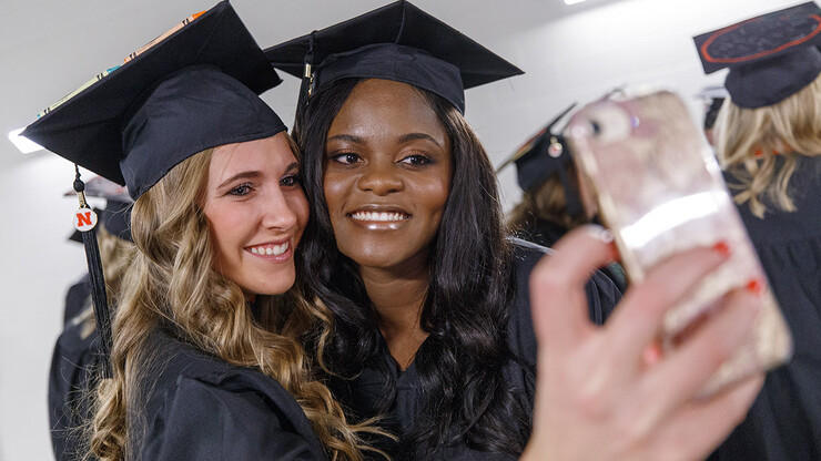 Emily Johnson and Olga Mwenentanda take a selfie while waiting for the undergraduate commencement ceremony to begin. Both earned a Bachelor of Science in Education and Human Sciences.