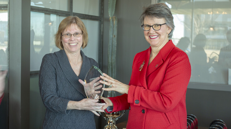 Jane Green (right) presents the Combined Campaign award for most unique creative campaign to Arts and Sciences representative Brenda Ensor. The college earned the honor for hosting "Pop Up" popcorn celebrations each week of the campaign. 