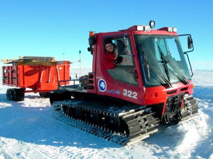David Harwood drives a Pisten Bully near McMurdo Station, towing a trailer with equipment for fieldwork at one of the ANDRILL (Antarctic Geological Drilling) Projects drill sites in 2006.