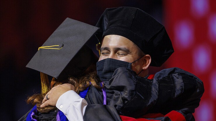Tyler Kozisek hugs his advising professor, Angela Pannier, after his doctoral hooding during the graduate and professional degree ceremony Dec. 17 at Pinnacle Bank Arena.