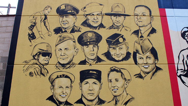 A mural featuring the faces of about a dozen Nebraska veterans.