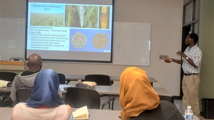 Stephen Wegulo (right), a professor and extension specialist in Nebraska’s Department of Plant Pathology, describes a range of significant plant diseases during a briefing session with the eight SEP fellows.