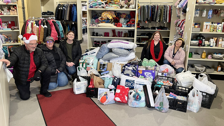 From left, Paul Brown, Becky Rowley, Ellyn McCarter, Megan Thomazin and Tina Pham take a photo with the large stack of items donated from the Dining Staff Council's 2022 holiday service project.