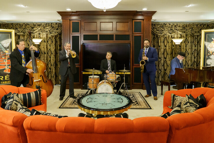 Metro Jazz Quintet performs in an elaborate lounge with an orange sofa.