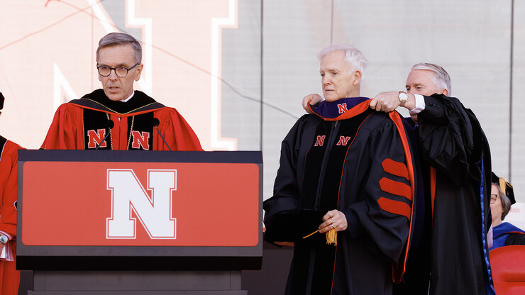 Bob Kerrey, former Nebraska governor and former U.S. senator for Nebraska, is hooded by University of Nebraska Regent Tim Clare during the undergraduate commencement ceremony May 20 at Memorial Stadium. Kerrey received an honorary Doctor of Law from the university. Chancellor Ronnie Green is at left.