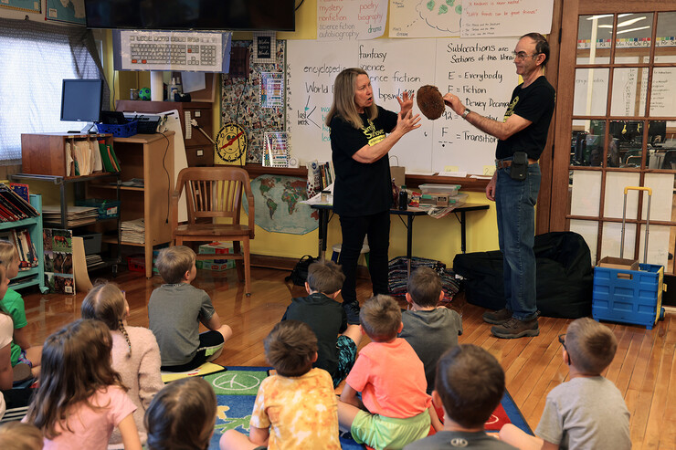 Alan and Jeanette Koelling, owners of Simply Sunflower Farms in North Loup, show off sunflower head to Burwell Elementary School students.