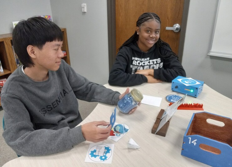 Lincoln Northeast students Richard Saw and Geniah Story sit at a table.