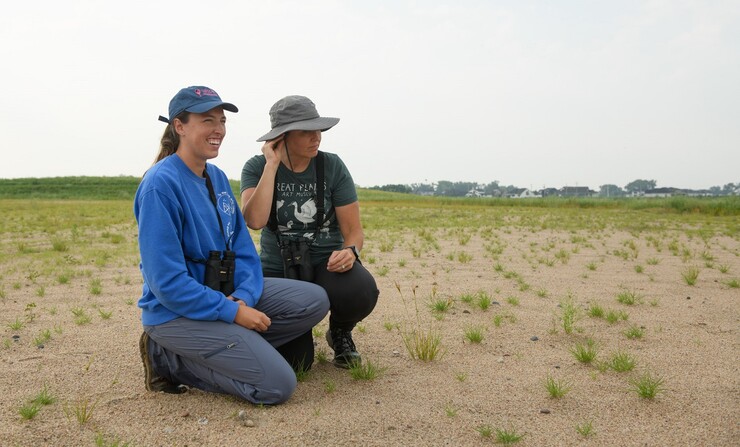 Alisa Halpin (right) holds a least tern egg up to her ear to listen for the small peeping sounds of a chick inside, soon to hatch. She's joined by her daughter, Summer Larkihn, a research technician with the Tern and Plover Conservation Partnership. Halpin had the same conservation position nearly a decade ago. (