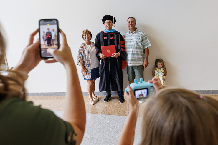 New Doctor of Education Jordan Engle poses for photos with family and friends after the ceremony.