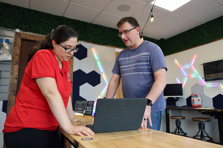 A 1to1 Technologies' employee talks with a customer about the security features on a MacBook Pro.