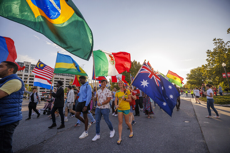 International students carry the flags of their native countries during the 2022 homecoming parade.