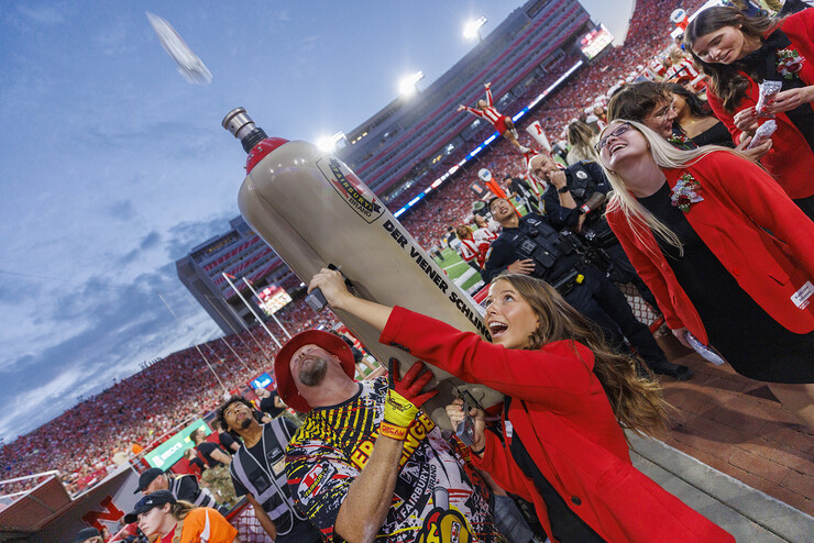 Soon-to-be-crowned homecoming royalty Emily Hatterman fires a hot dog into the crowd with Der Viener Schlinger before halftime of the Nebraska-Indiana football game on Oct. 1, 2022.