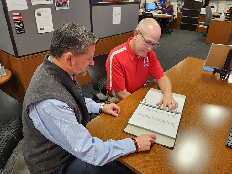 Thomas Allison, assistant director of the Military and Veteran Success Center, and center director Joe Brownell look over the list of Nebraskans killed in action in advance of the National Roll Call.