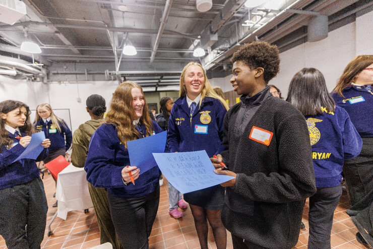 About a dozen FFA members, most in blue coats, talk to one another.
