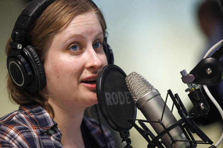 Rachael Wagner, a Husker doctoral student, wears headphones and speaks into a microphone.