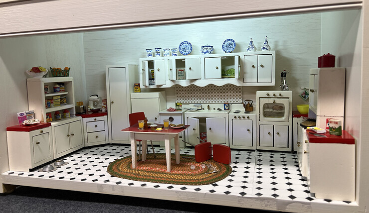 The C. Lauer and Clara Ward kitchen, as depicted in miniature, includes broken glass and cabinets and countertops in disarray.