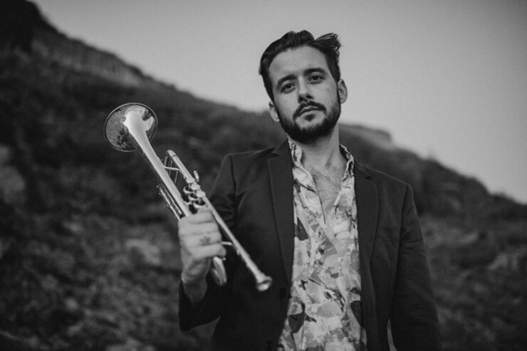 Black-and-white portrait of Jay Jennings holding a trumpet.