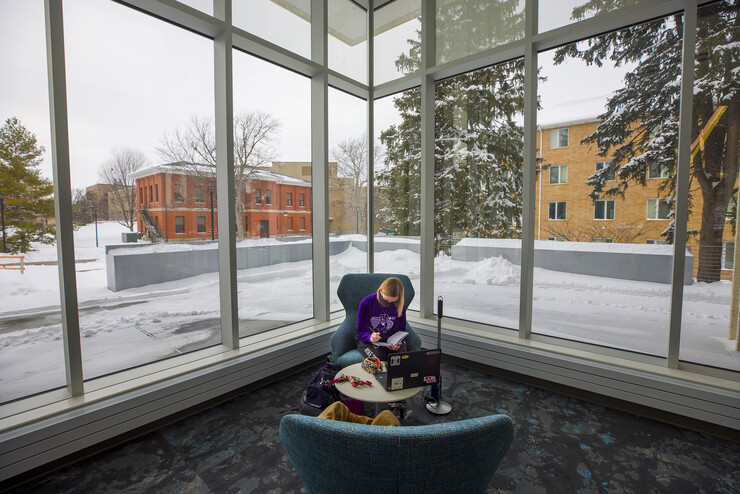 Lydia Cole, a senior from Plattsmouth, NE, studies in the corner seat ner the windows of the Dinsdale Family Learning Commons on East Campus.