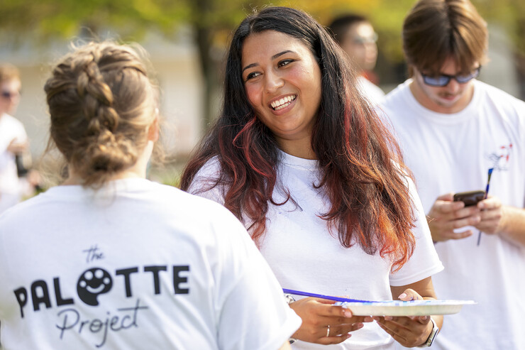 Erika Casarin, senior management major and founder of the The Palette Project, talks with a volunteer painter during the Sept. 1 event on campus.