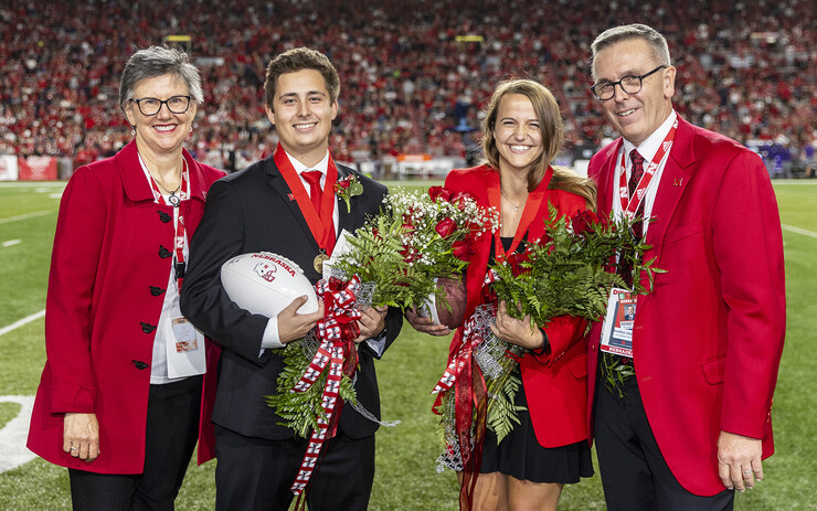 Nebraska’s American Ninja Warrior competitor Leigh Jahnke (third from left) stands on the field of Memorial Stadium after being named homecoming royalty on Oct. 2 during the football game with Northwestern University. Jahnke is pictured with (from left) Jane Green, Bobby Martin and Chancellor Ronnie Green. 