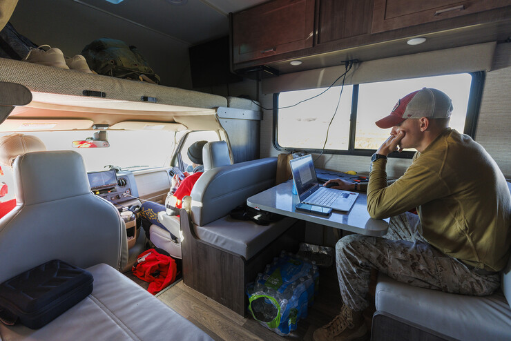 Tyler Kluthe, Marine Corp reservist and a junior construction management major from Lincoln, catches up on homework as he rests in the RV along with Everett Bloom and Dave Rangeloff