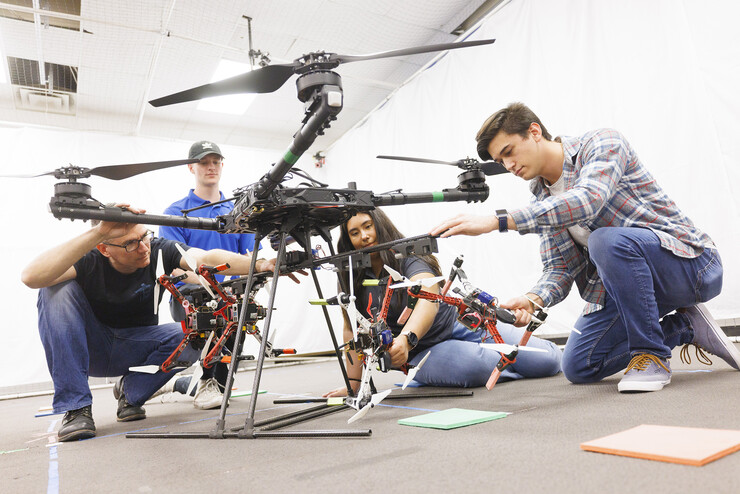 Engineering students loading up the drone with baby drones in April 2022.