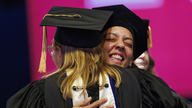 Marissa Oliver hugs Emily Kazyak, her faculty adviser. after receiving her hood during the ceremony.