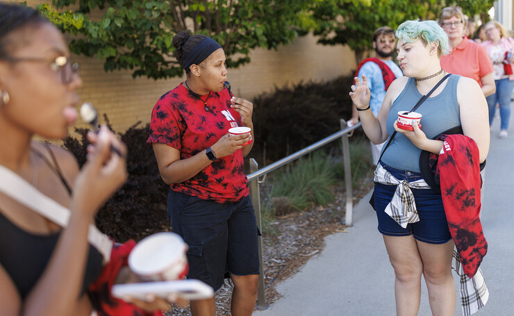 Rain Stidwell (right) chats with Brannon Evans as the two eat Dairy Store ice cream while waiting in a line at a food truck during the College of Fine and Performing Arts’ welcome event on Aug. 18.