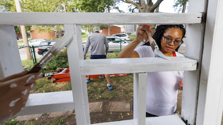 Nebraska Law's Tatiana Eskridge brushes paint on railings of a house along S. 27th Street as part of the college's annual participation in Lincoln's Paint-A-Thon. The event is a community outreach that paints homes of families in need. Students, faculty and staff from the College of Law participate in the event each year.