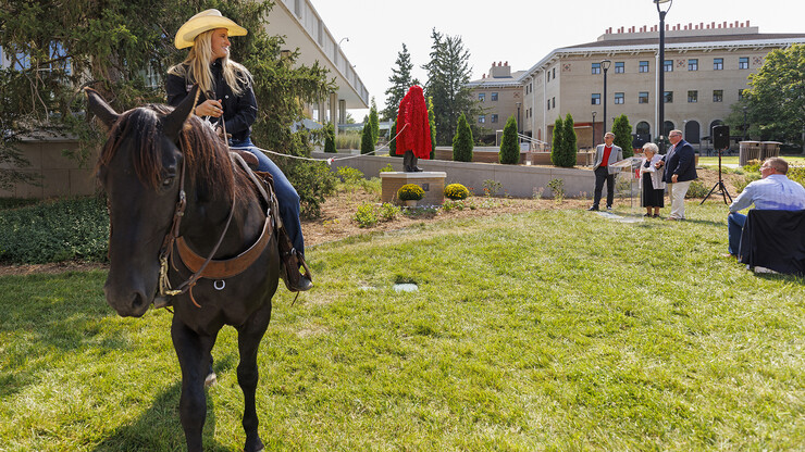 Hallie Reeves, a senior and a member of the UNL Rodeo Club, uses her horse to unveil the statue of George Beadle. The dedication event included honoring university supporters Bill and Ruth Scott.
