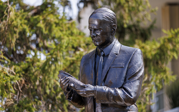 The bronze, life-sized sculpture of George Beadle features the Nobel Prize-winning Husker examining a corn cob. The sculpture was designed by Matthew Placzek.