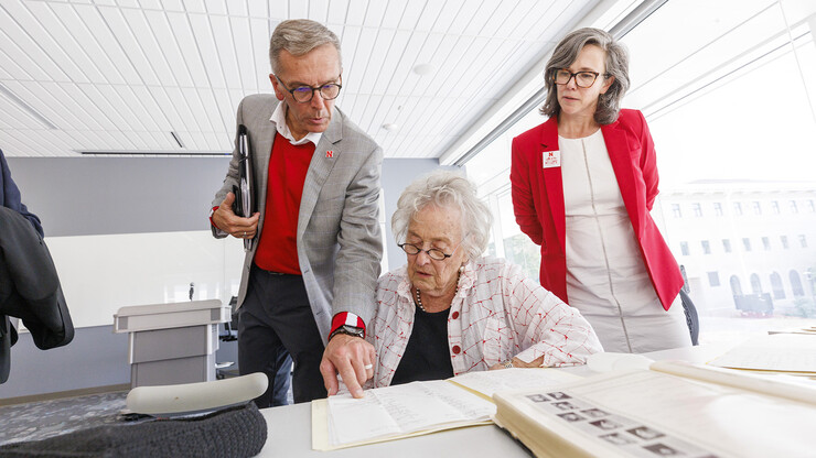 Chancellor Ronnie Green (from left), Ruth Scott and Claire Stewart, dean of the University Libraries, examine correspondence from George Beadle during a stop in the Dinsdale Family Learning Commons. The historic items are part of the University Archives and Special Collections.