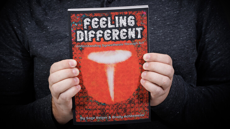 Sage Reiger holds a copy of his book, "Feeling Different."