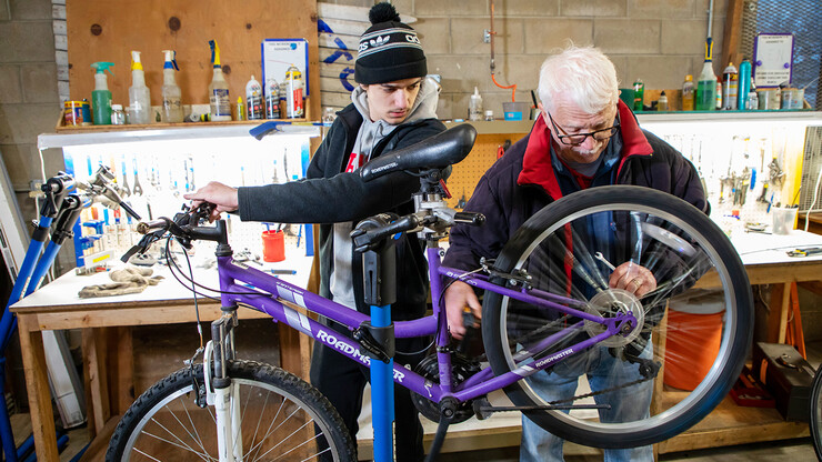 Nebraska Engineering student Jacob Dalton (left) works with mentor Clayton Streich to repair a bike in the Lincoln Bike Kitchen. The Bike Kitchen is among a number of local organizations that the College of Engineering works with to offer service learning opportunities to its students.