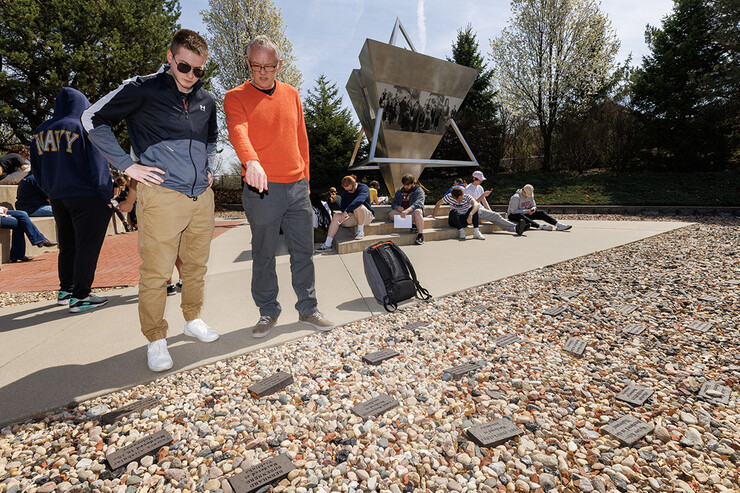 Gerald Steinacher, professor of history, tells Nick Scholtes, a senior from Lincoln, the stories behind the memorial bricks for a person murdered in the holocaust with ties to Nebraska. History of the Holocaust course students visit the Holocaust memorial in Lincoln’s Wyuka Cemetery.