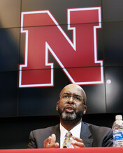 Rodney Bennett talks while seated at a table, with a Nebraska "N" showing on the screen behind him in the Wick Alumni Center.