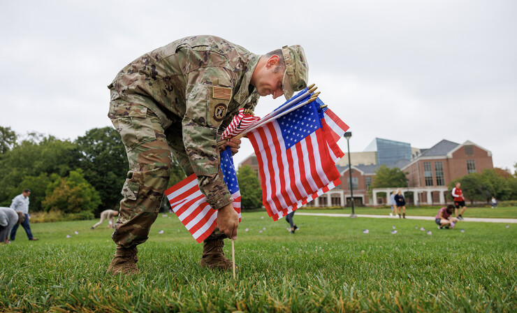 Air Force Lt. Col. Phil Garito plants American flags around a section of the green space north of the Nebraska Union.