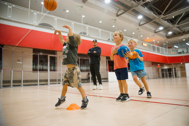 Itty Bitty Sports participants practice shooting a basketball.
