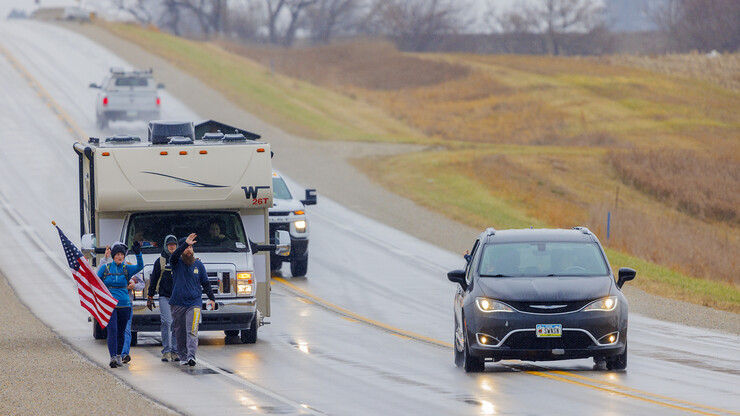 Iowa veterans Dawn Walton and Casey Swanson wave to a passing car as they walk along Highway 83 east of Atlantic, Iowa, on Nov. 20.