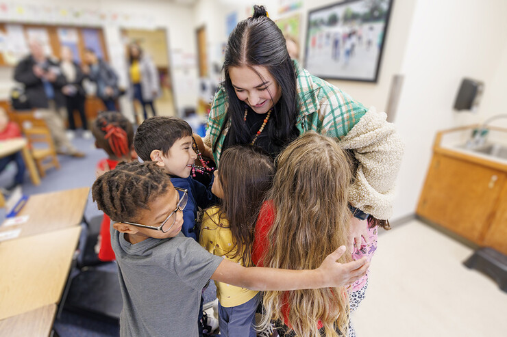 Crandall Blake receives a massive hug from several students when she returned to her classroom for one last time. 
