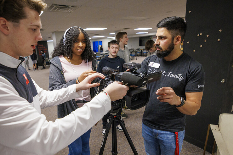 Alex Fernando checks to see if Lefler Middle School student Kaleigh Stockard-Smith can hear the interviewee as CoJMC Ambassador Harmon Johnsen adjusts the sound levels.