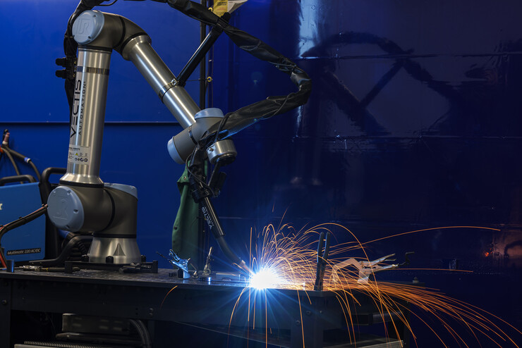  A robotic welder works it’s way around a metal sculpture.